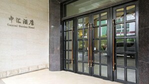 A hotel entrance with a sign reading "Central Garden Hotel" and a set of double doors with a glass panel. - Zhonghui Hotel (Lingchuan)