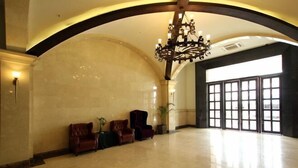 A spacious lobby with a high ceiling, a grand chandelier, and a large window with multiple panes. - Zhonghui Hotel (Lingchuan)