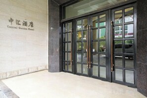 A hotel entrance with a glass door, a sign above the door, and a paved walkway leading to the entrance. - Zhonghui Hotel (Lingchuan)