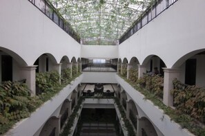A courtyard with arches, a central staircase, and greenery. - Zhonghui Hotel (Lingchuan)