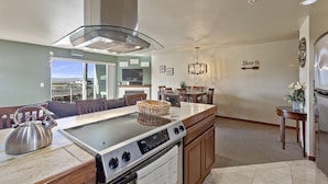 Una cucina moderna con isola centrale, forno integrato e zona pranzo con vista.