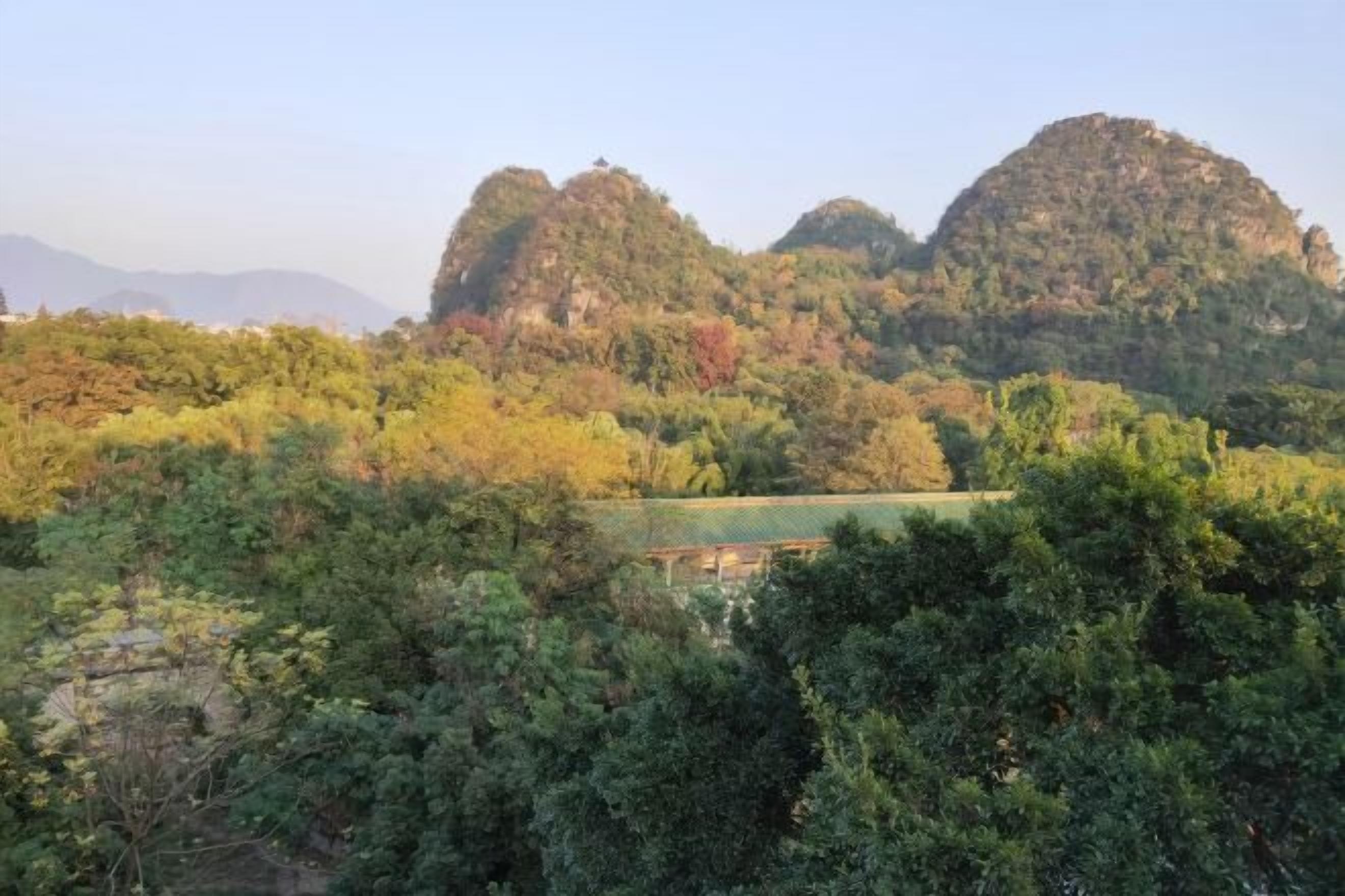 Un paysage montagneux, caractérisé par une végétation luxuriante et une petite construction au premier plan.