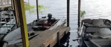 A covered dock area with boats and a ladder.