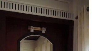 Une porte en bois avec un miroir au-dessus et une chaise devant.