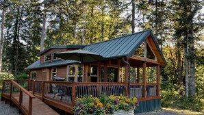 A cabin with a deck, a covered porch, and a gravel driveway. - Magical Forest Cabin- Secluded Retreat Near Beach (Lakebay)