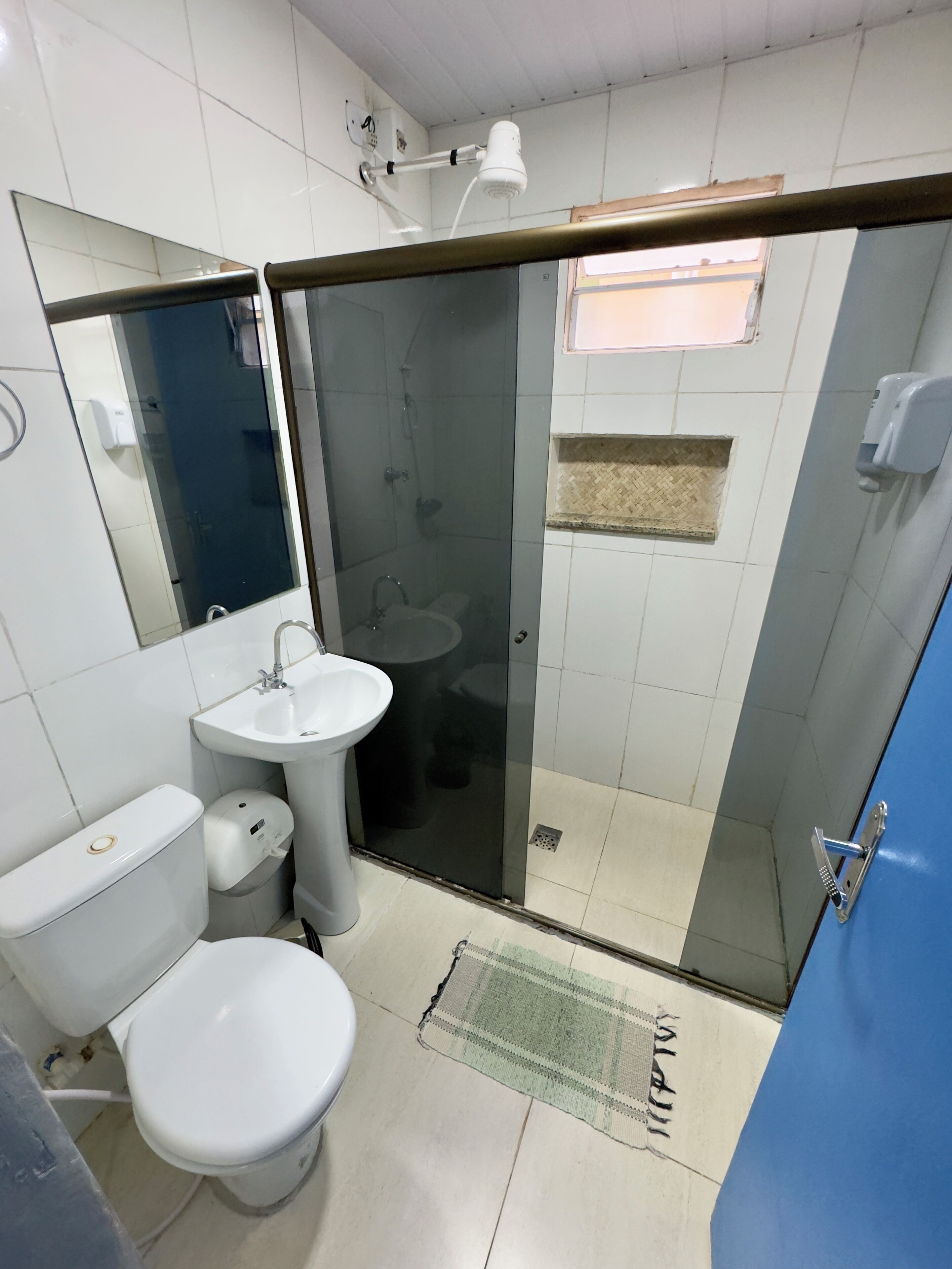 A bathroom with a toilet, sink, and glass-enclosed shower.