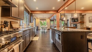 Una cocina moderna con electrodomésticos de acero inoxidable, vigas de madera y una isla grande.