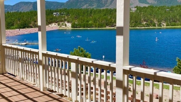 A covered outdoor area with a view of a lake and mountains. - ON THE LAKE Monument & USAFA Mountain View Home. 30 DAY MINIMUM (Monument)