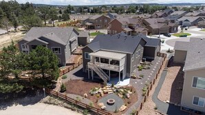 A residential area with modern houses, a central building with a balcony, and a well-maintained driveway. - ON THE LAKE Monument & USAFA Mountain View Home. 30 DAY MINIMUM (Monument)