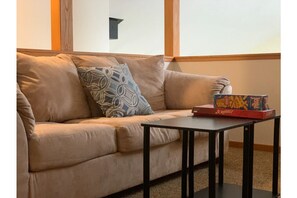 Relax in this stylish space with a comfortable sofa, coffee table, and Scrabble game.
