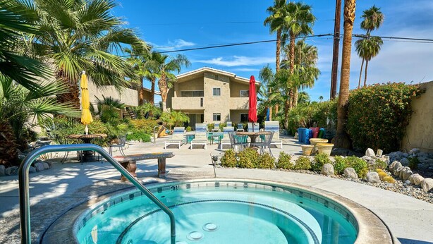 A swimming pool with a hot tub, surrounded by palm trees and outdoor seating. - Quaint Palm Springs Condo
City I.D. 032692 (Palm Springs)