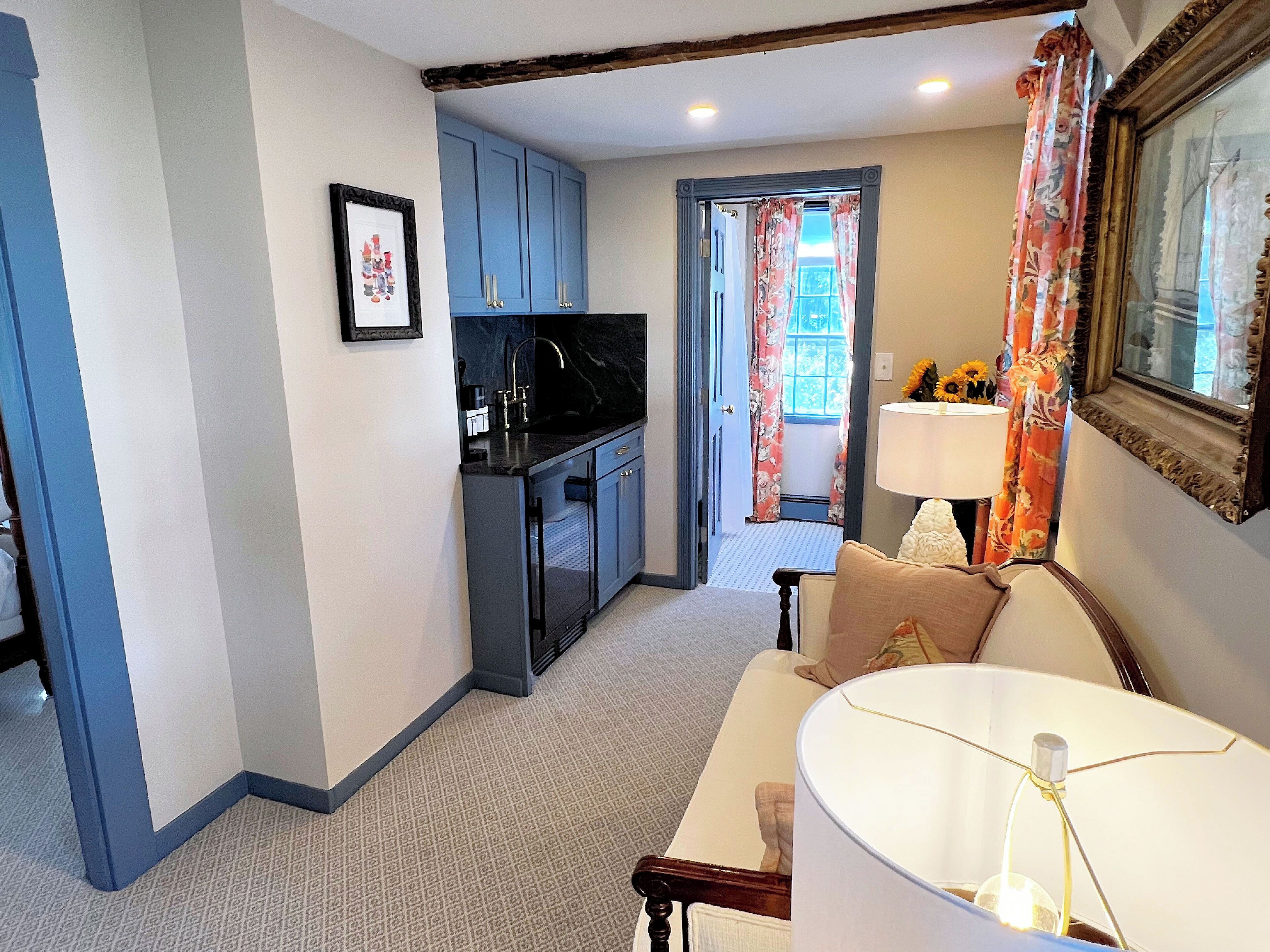 A compact living space with a kitchenette, a sofa, and a dining table.