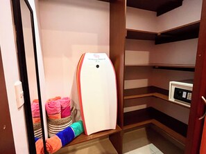 Une chambre de taille réduite équipée d’un four à micro-ondes, d’un petit réfrigérateur et de serviettes soigneusement pliées.