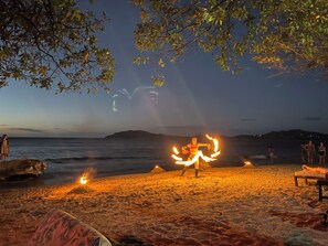A beach scene with a fire performance.