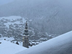 A snow-covered village with a prominent church tower and traditional buildings. - New! Beautiful "ski-in, ski-out" duplex apartment in the center of La Clusaz (La Clusaz)