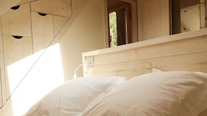 A bedroom with a wooden headboard, a bed with white linens, and a skylight above. - New! Beautiful duplex "ski in ski out" La Clusaz center  (La Clusaz)