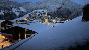 A snow-covered village with traditional wooden houses and a prominent church tower. - New! Beautiful duplex "ski in ski out" La Clusaz center  (La Clusaz)