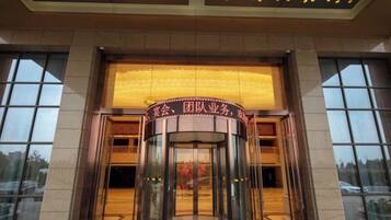 A revolving door entrance with a sign above it.