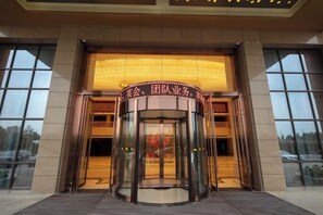 A revolving door entrance with a sign above it. - Jiade Hotel (Tongxiang)