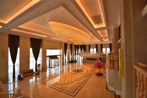 A spacious lobby with a high ceiling, a central circular light fixture, and a patterned floor design. - Jiade Hotel (Tongxiang)