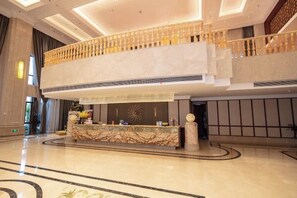 A spacious lobby with a marble reception desk, a second-floor balcony, and a modern ceiling design. - Jiade Hotel (Tongxiang)