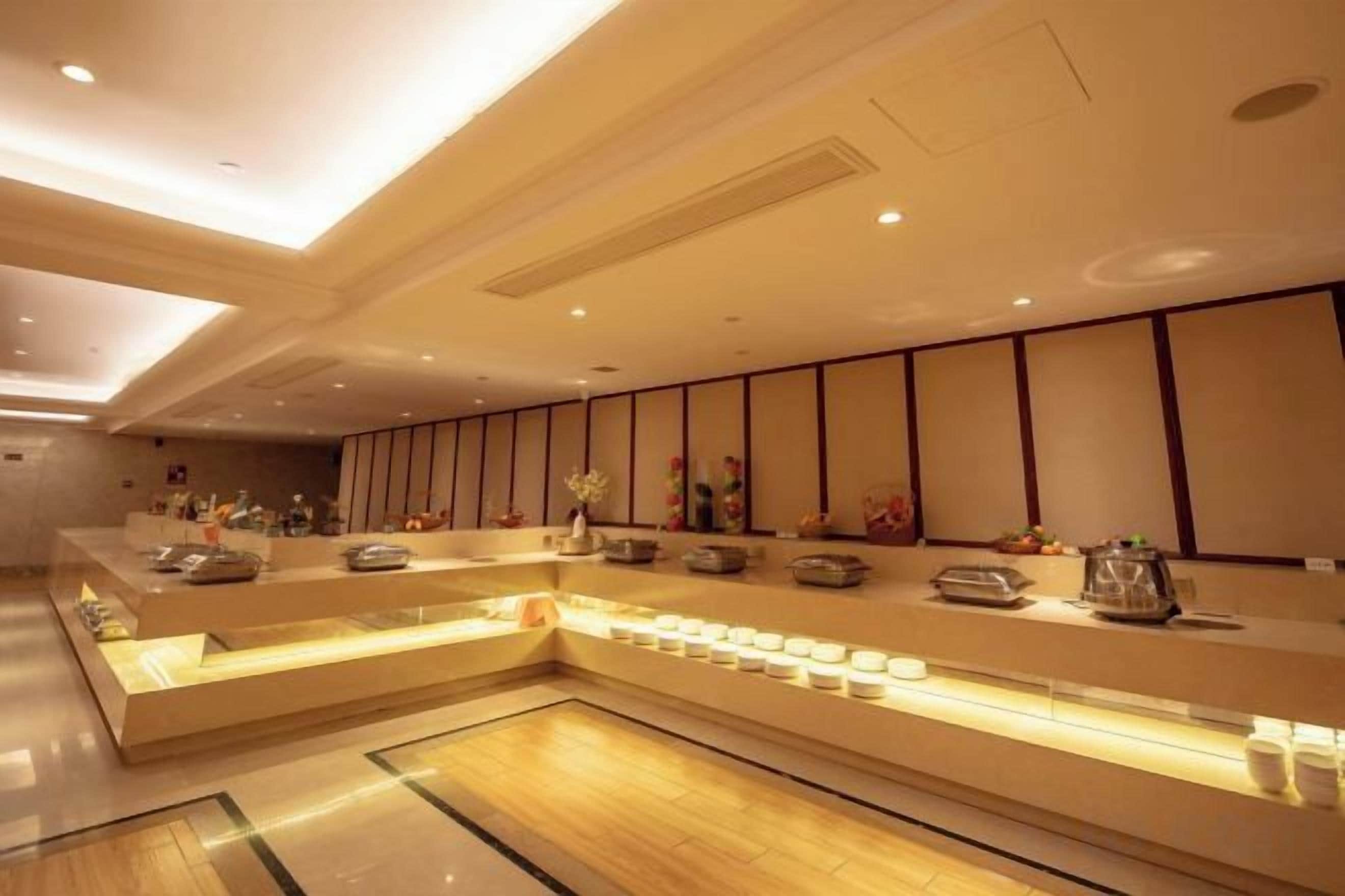 A hotel reception area with a long counter, seating area, and decorative elements.