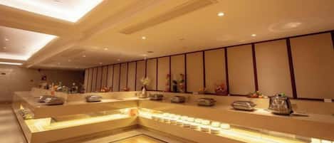 A hotel reception area with a long counter, seating area, and decorative elements.