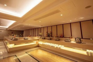 A hotel reception area with a long counter, seating area, and decorative elements. - Jiade Hotel (Tongxiang)