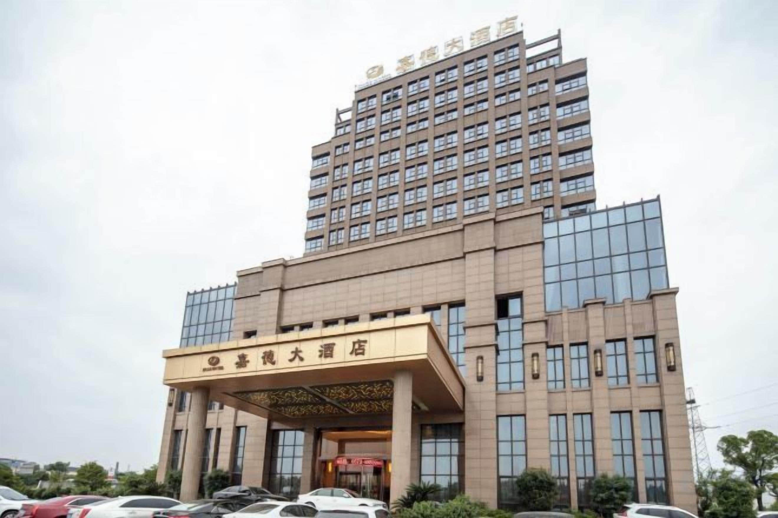 A multi-story hotel with a prominent entrance and a large sign.