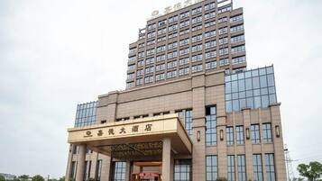 A multi-story hotel with a prominent entrance and a large sign.