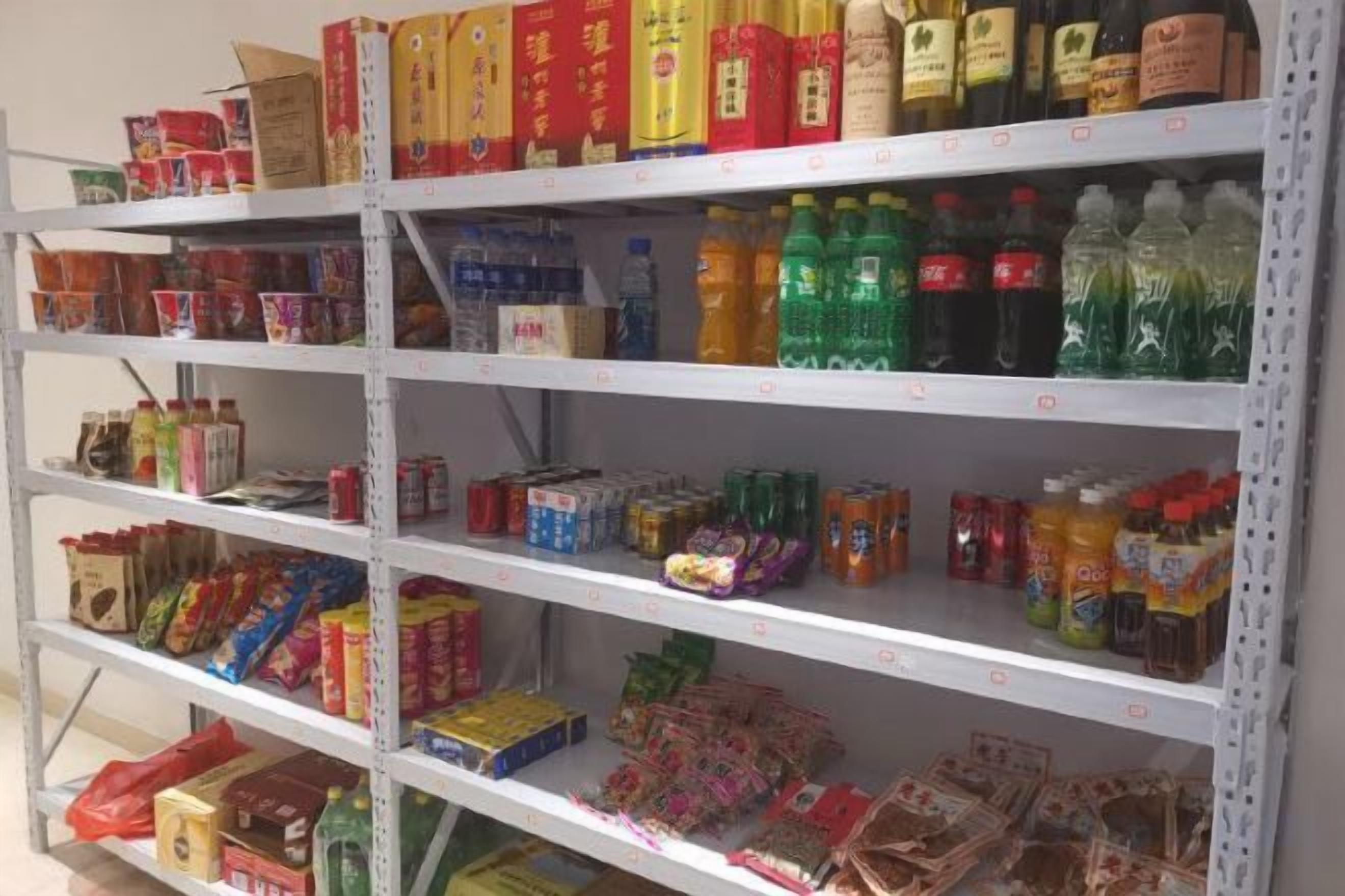 A shelf stocked with various packaged goods including beverages, snacks, and other food items.