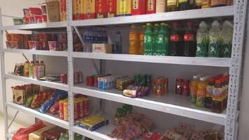 A shelf stocked with various packaged goods including beverages, snacks, and other food items.