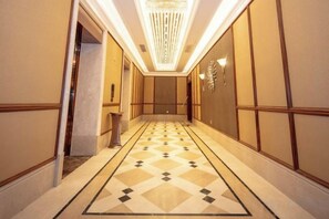 A hallway with a patterned floor, recessed lighting, and a door at the end. - Jiade Hotel (Tongxiang)
