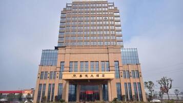 A tall hotel building with a modern design, featuring a prominent entrance and multiple floors.