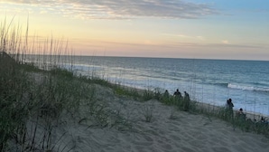 Una spiaggia con dune sabbiose e l'oceano.