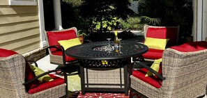 A patio with wicker furniture and red cushions, a round table, and a bottle of wine. - Downtown Luxury Charleston-style Row House/near Bruce's Field/Horse District (Aiken)
