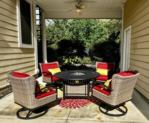 A covered patio with wicker furniture, a round table, and a red and yellow patterned rug. - Downtown Luxury Charleston-style Row House/near Bruce's Field/Horse District (Aiken)