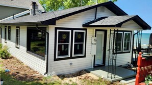 Ein eingeschossiges Haus mit Veranda, Garage und einem kleinen Anbau.