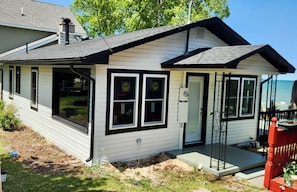 A single-story house with a front porch, a garage, and a small attached structure.