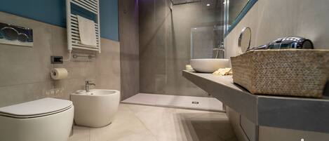 Une salle de bain moderne avec des toilettes, un bidet et un grand miroir.