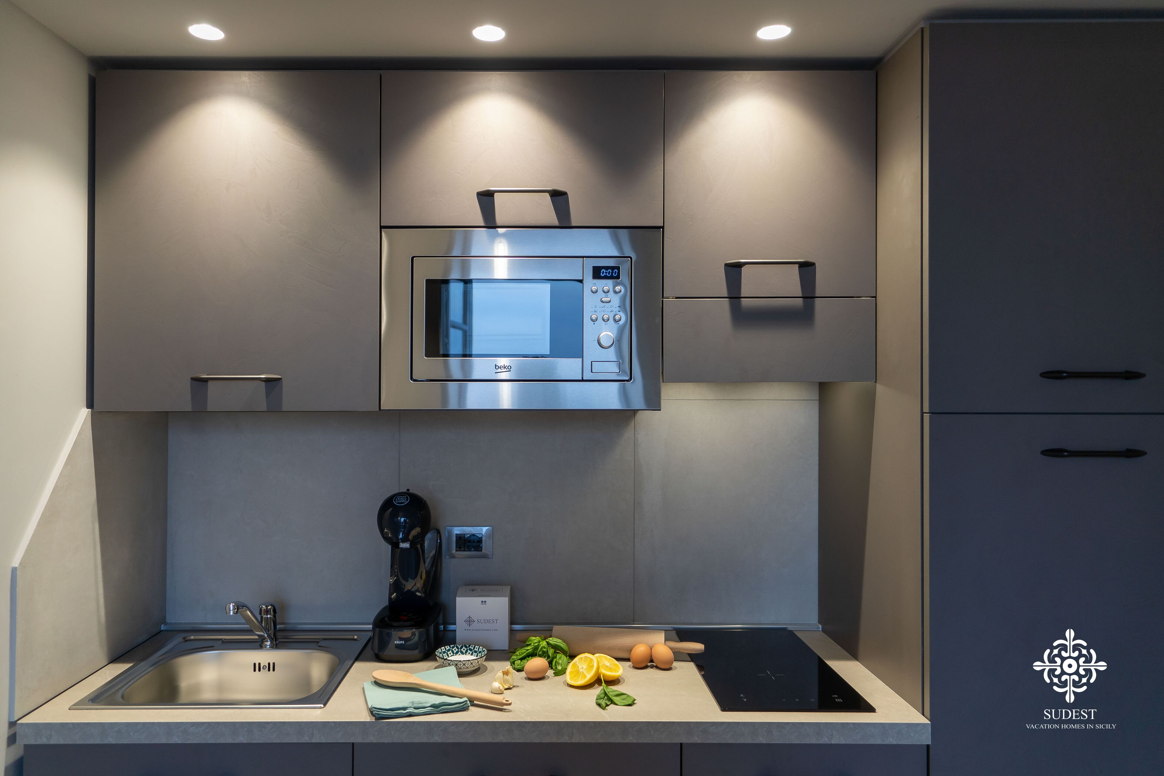 A modern kitchen with a built-in microwave, a coffee maker, and fresh ingredients on the counter.