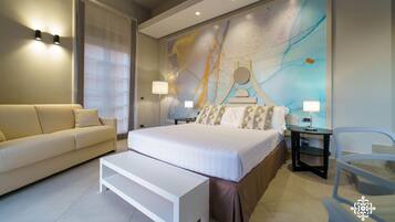 Une chambre d’hôtel moderne avec un grand lit, un canapé, une petite table et une chaise.