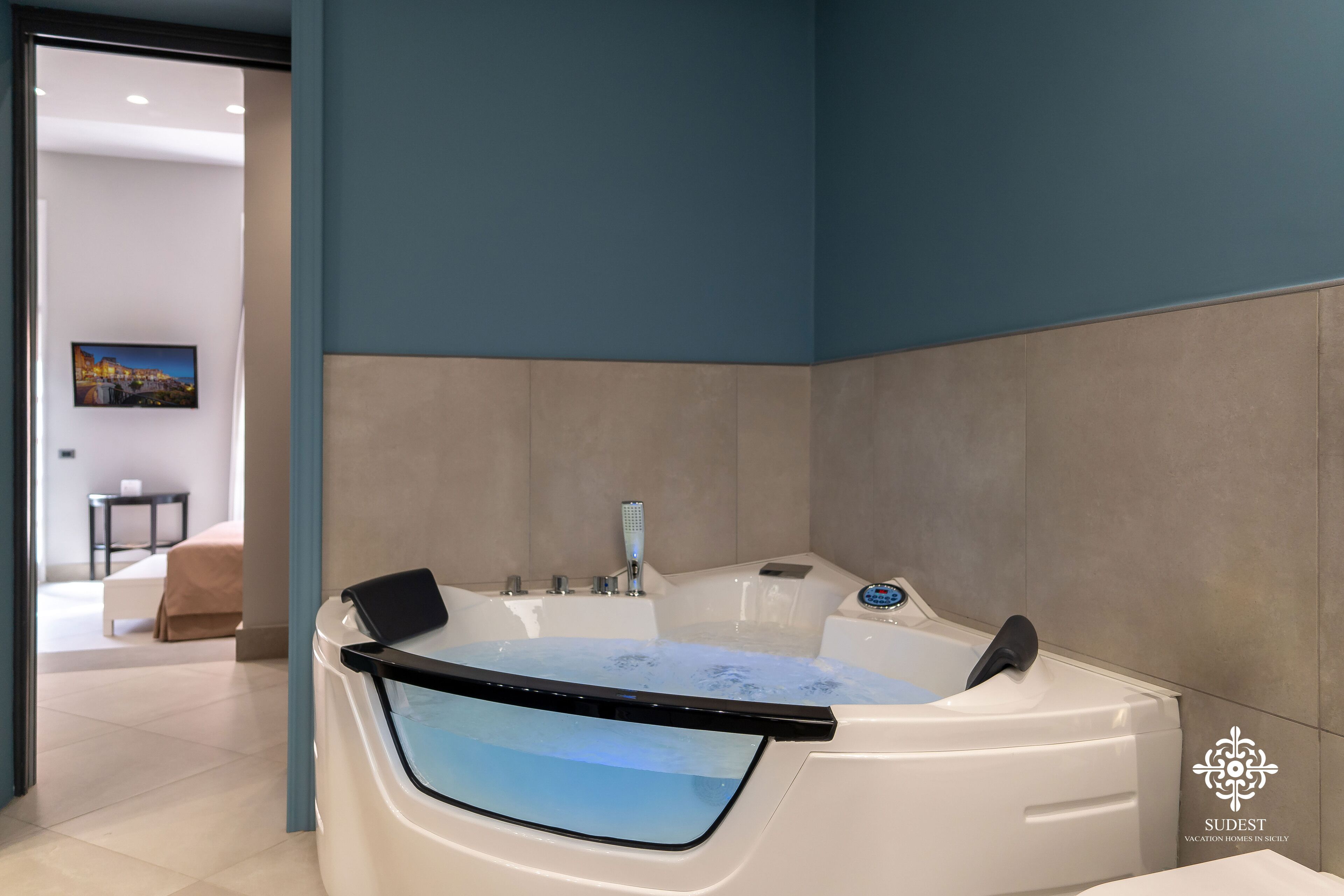 Un baño moderno con una bañera grande, una ducha con mampara de vidrio y vistas a un paisaje urbano.