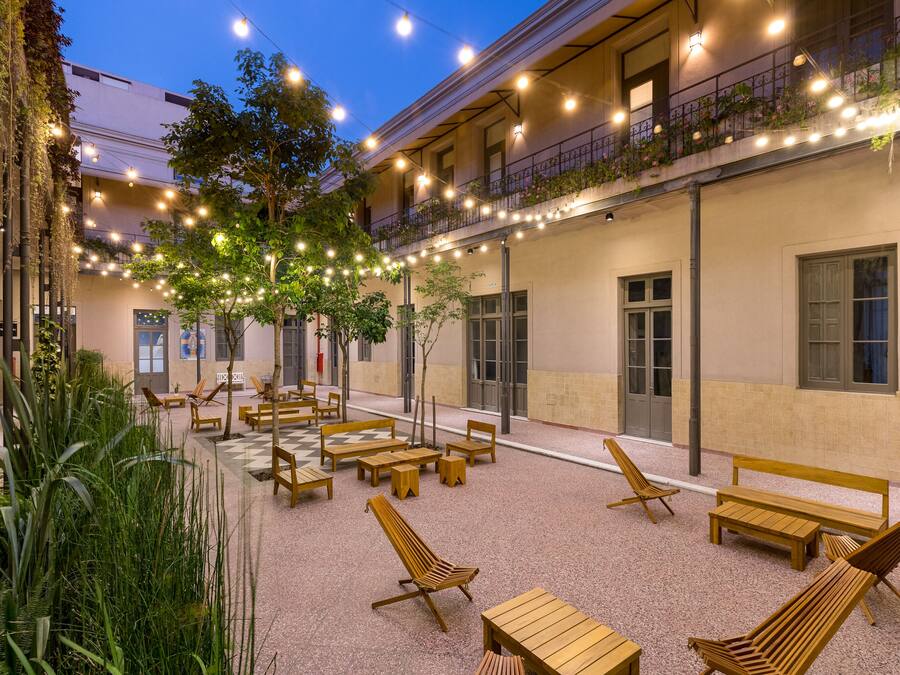 An outdoor seating area with wooden furniture and string lights.