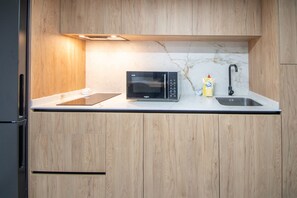 Een magnetron, een kookplaat, kookgerei, borden en bestek