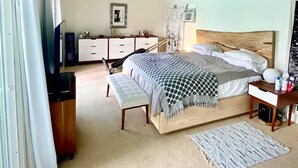 A bedroom with a bed, bedside tables, a bench, a dresser, and a TV. - South Laguna Beach summer rental near Montage Resort (Laguna Beach)
