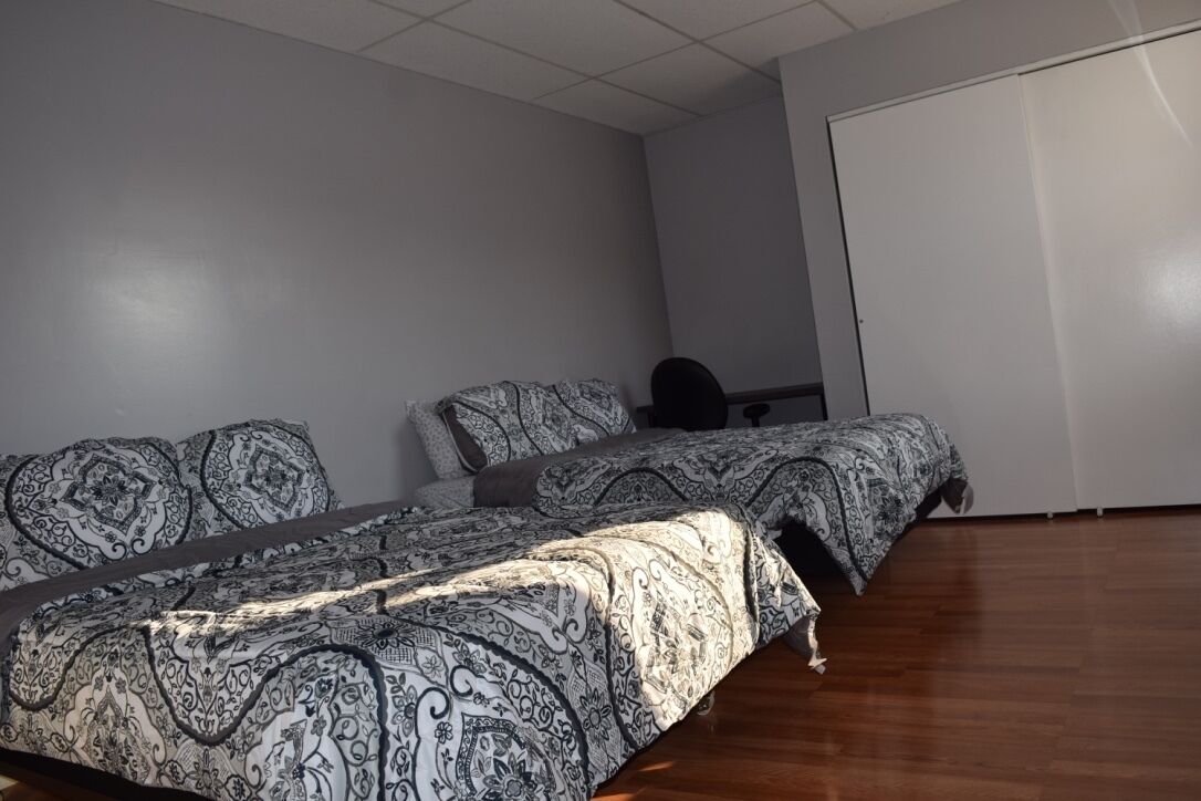 Un dormitorio con una cama grande, un escritorio y un armario.