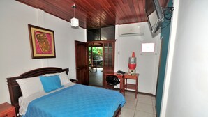 A bedroom with a bed, a desk, and a chair. - Isla Azul Hotel (Puerto Ayora)