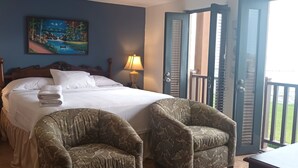 A bedroom with a bed, two lamps, a painting, and a balcony with a railing. - Suite San Juan 125 Gran Pacifica Resort (Villa El Carmen)