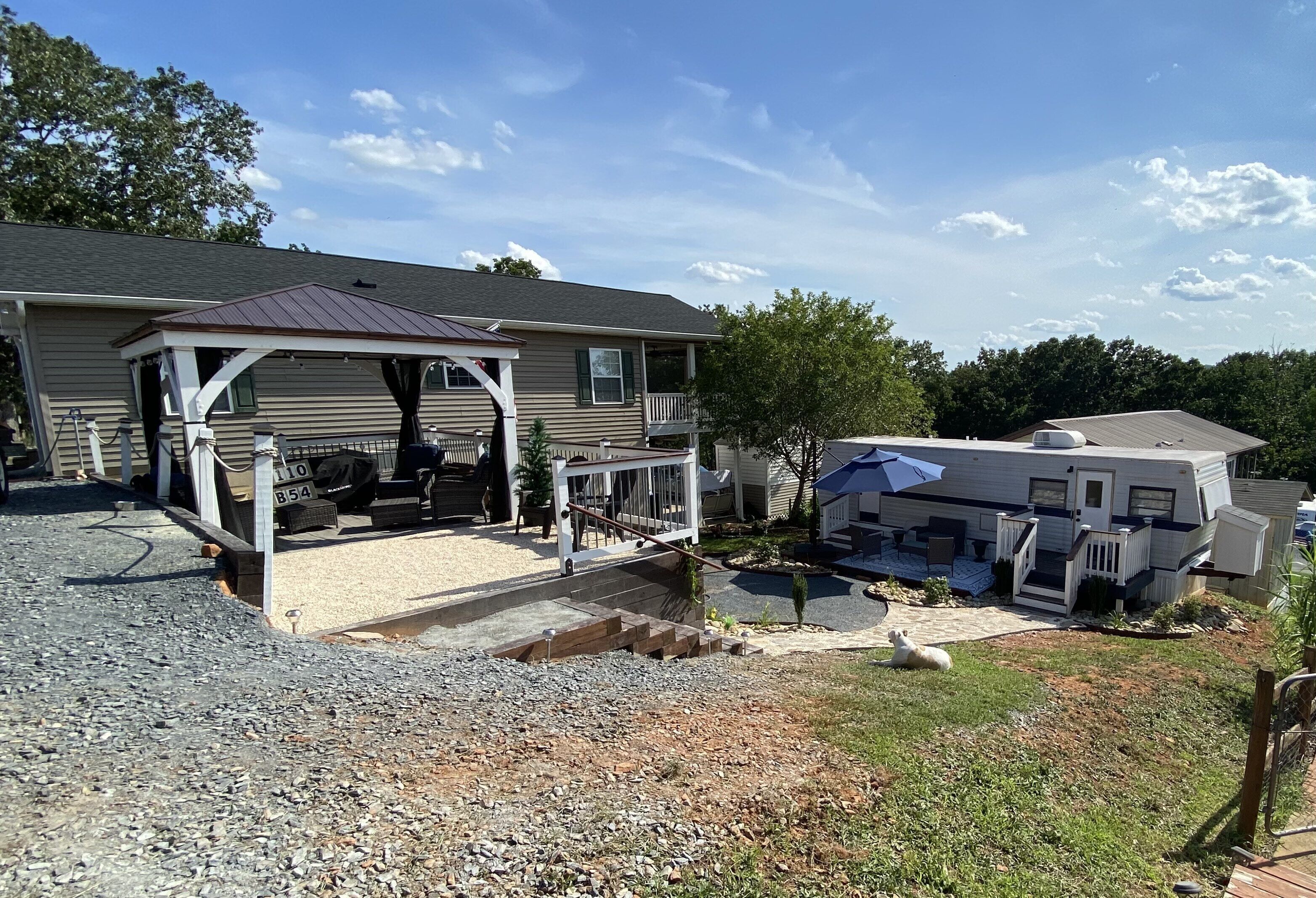 A house with a covered porch, a gravel driveway, and a small garden.